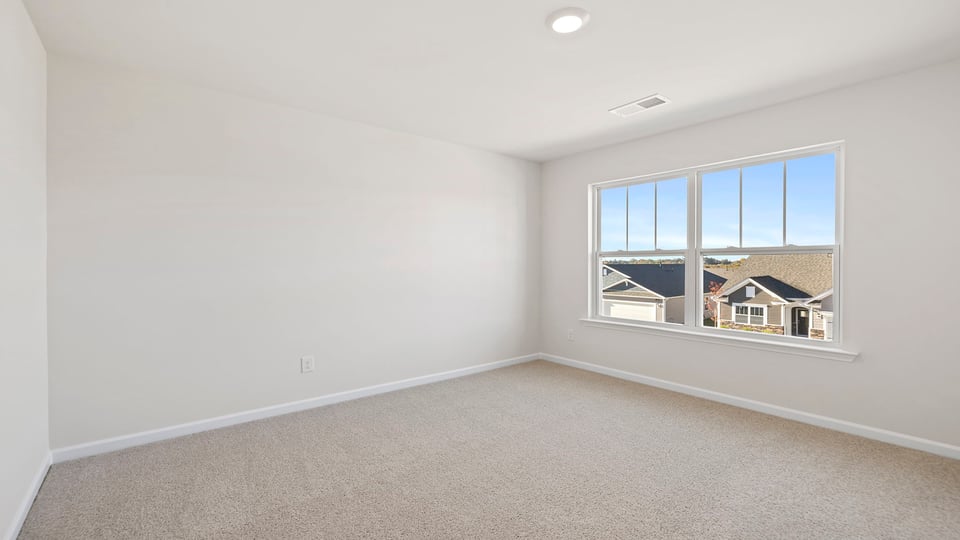 Bedroom with carpet and window.
