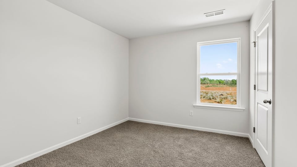 Bedroom with carpet and window.