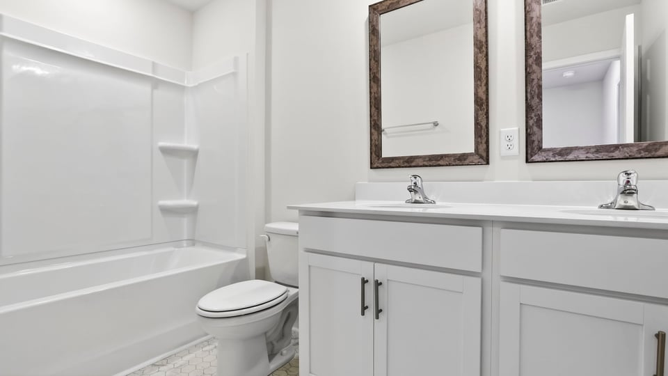 Bathroom with double vanity sink and tub.