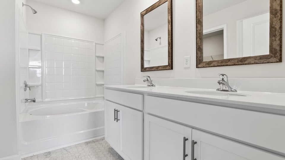 Bathroom with double vanity sink and tub.