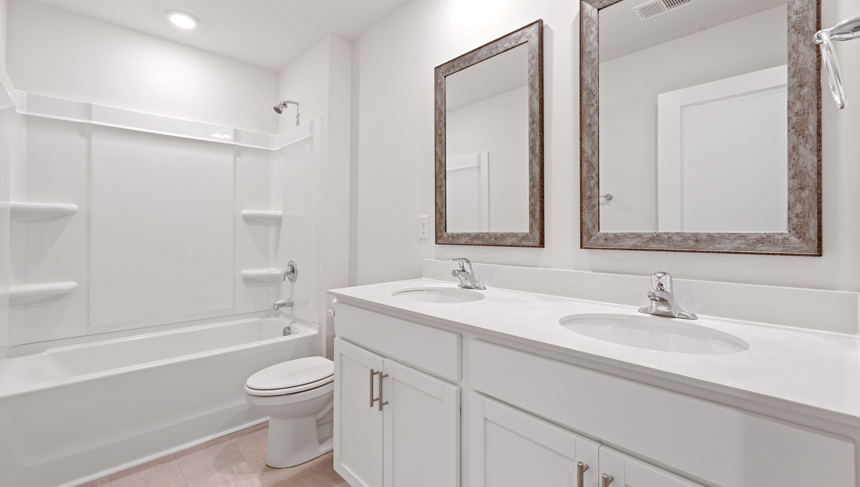 Bathroom with dual vanity and tub/shower combo.