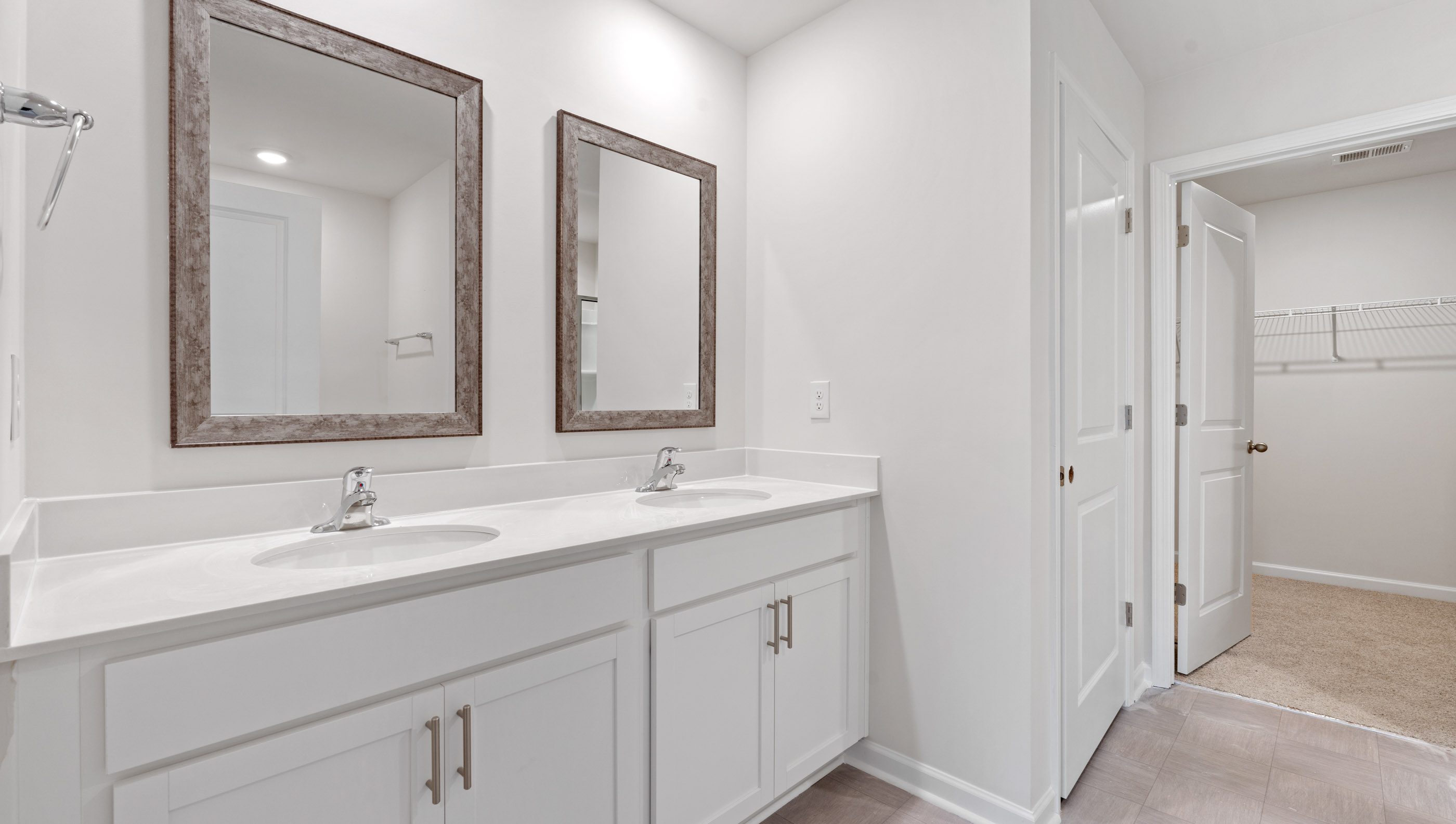 Bathroom with dual vanity looking towards closet.