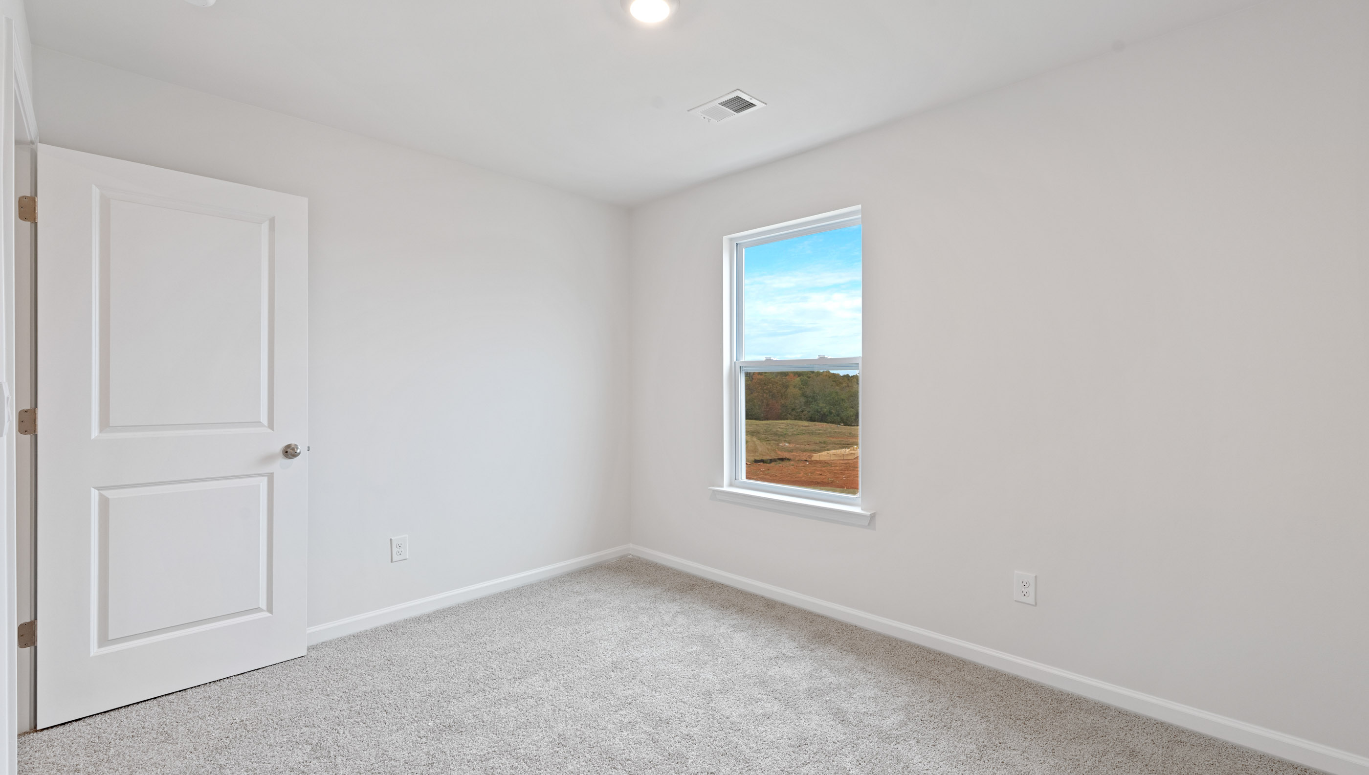Bedroom with carpet and window.
