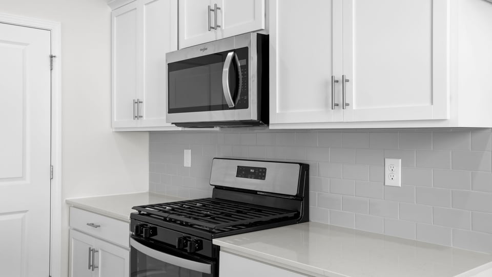 Kitchen and island with quartz countertops and stainless steel appliances.