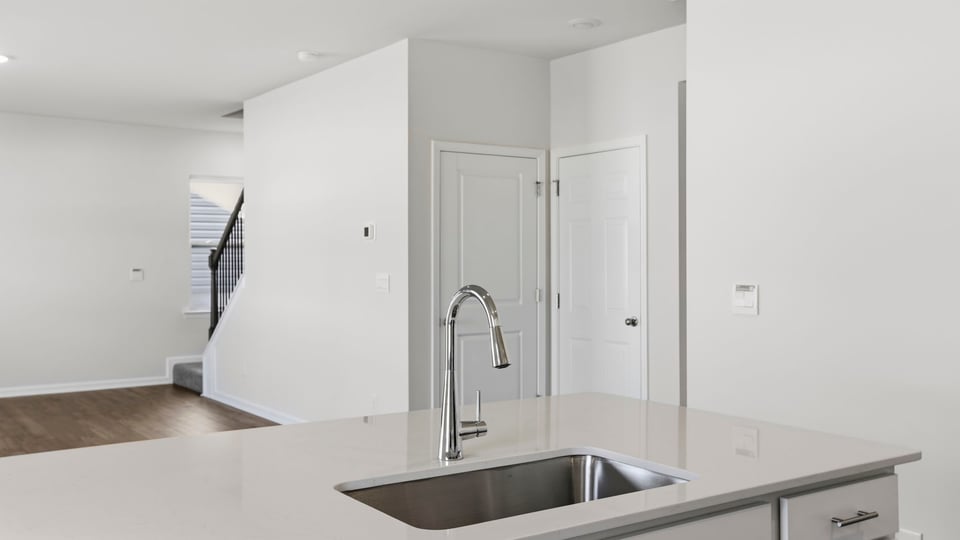 Kitchen and island with quartz countertops and stainless steel appliances.
