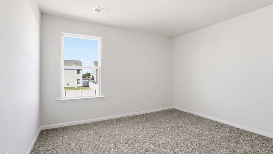 Bedroom with carpet and window.