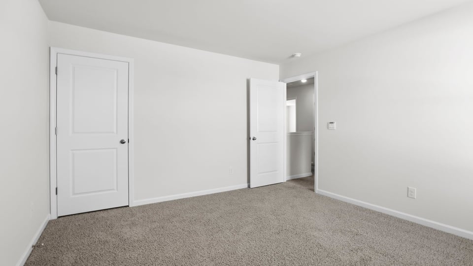 Bedroom with carpet and window.