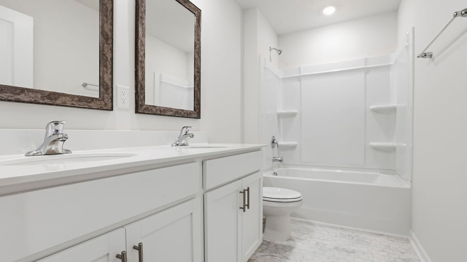 Bathroom with double vanity sink and tub.