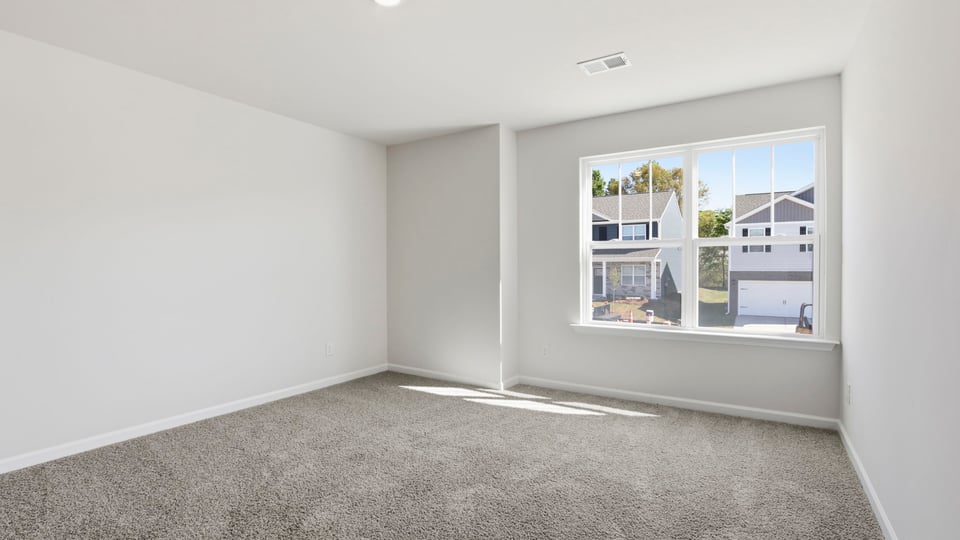 Bedroom with carpet and window.
