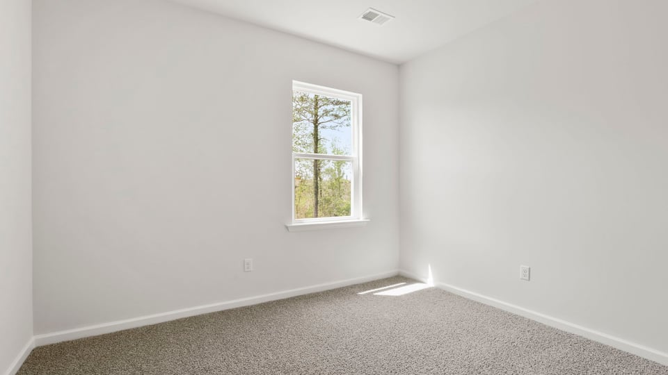Bedroom with carpet and window.