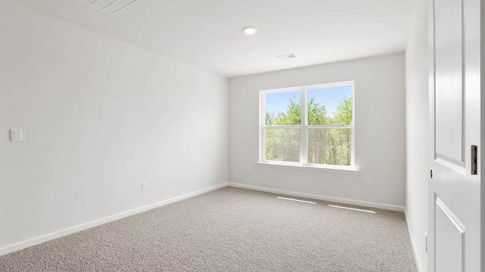 Bedroom with carpet and window.