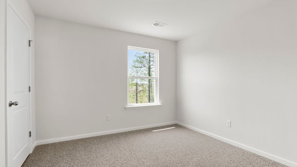 Bedroom with carpet and window.