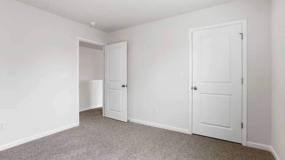Bedroom with carpet and window.