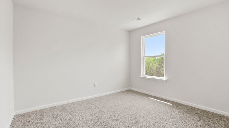 Bedroom with carpet and window.