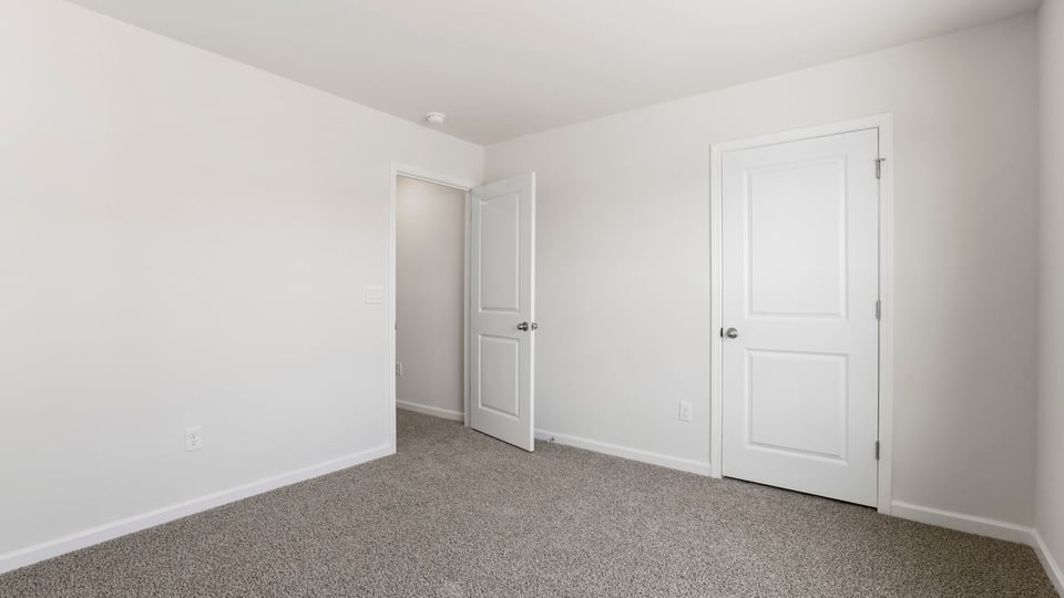 Bedroom with carpet and window.
