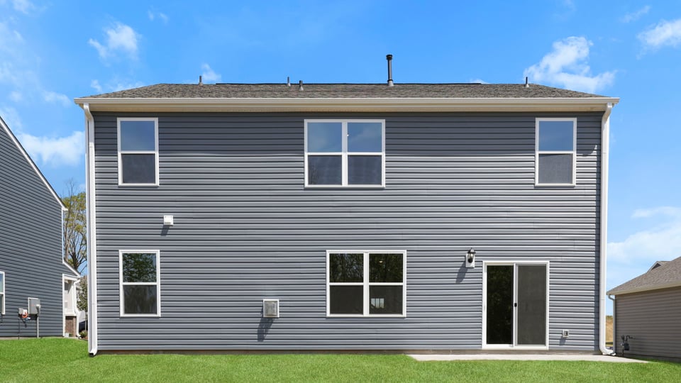 Back exterior of home with large backyard.