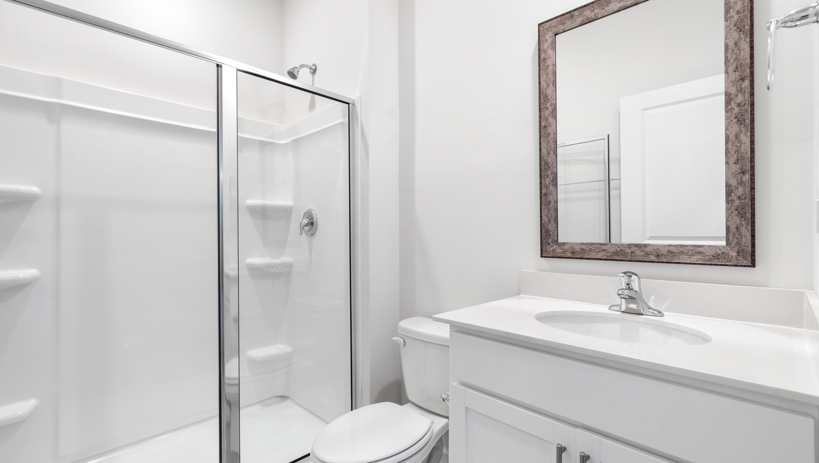 Bathroom with vanity and walk in shower.