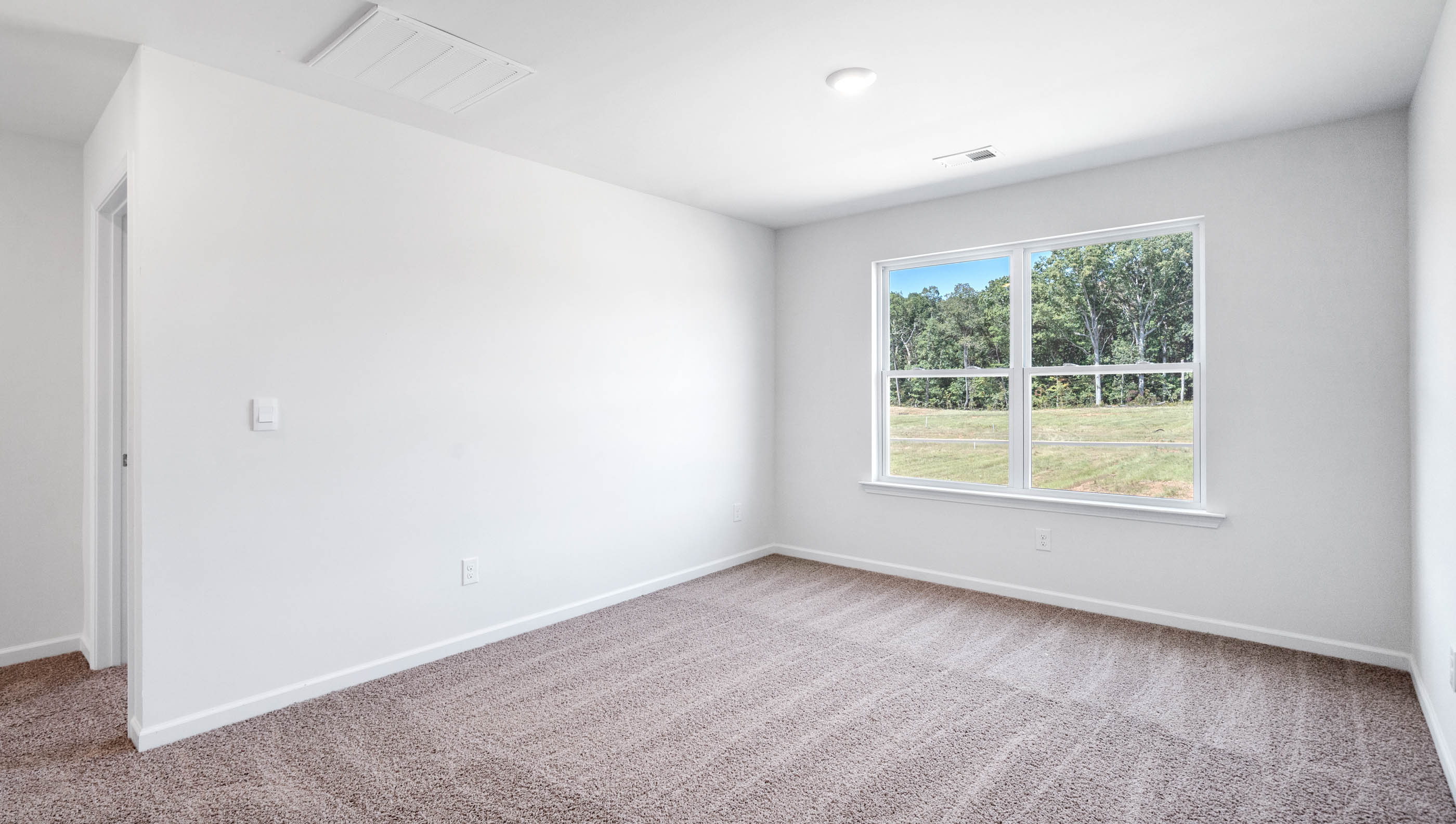 Bedroom with carpet and windows.