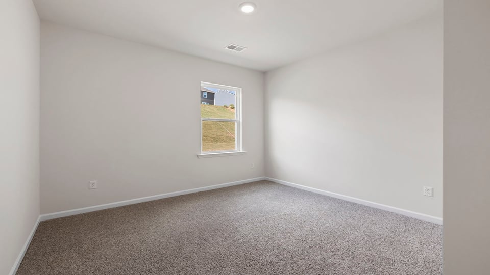 Bedroom with carpet and windows.