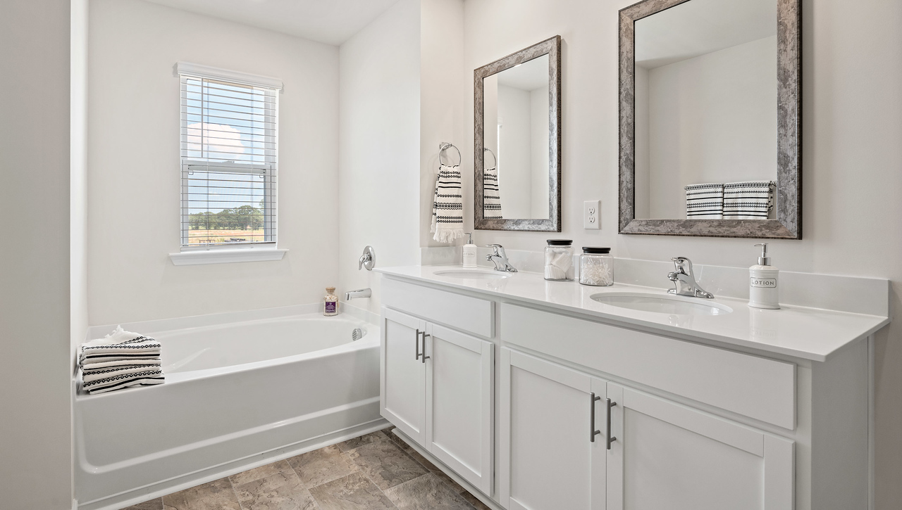 Bathroom with double vanity sink and tub.