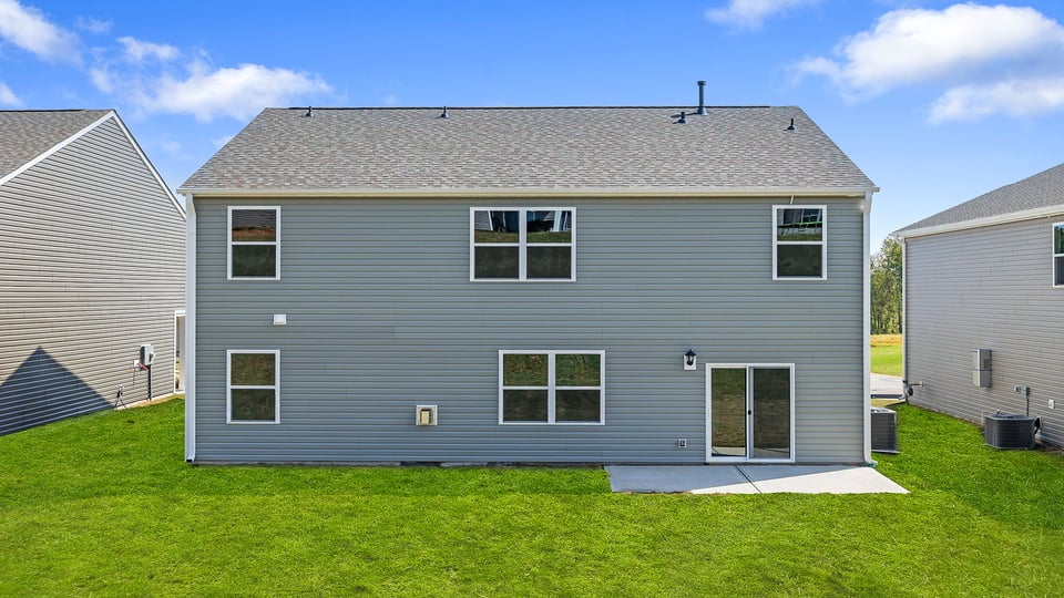 Back exterior of home with large backyard.