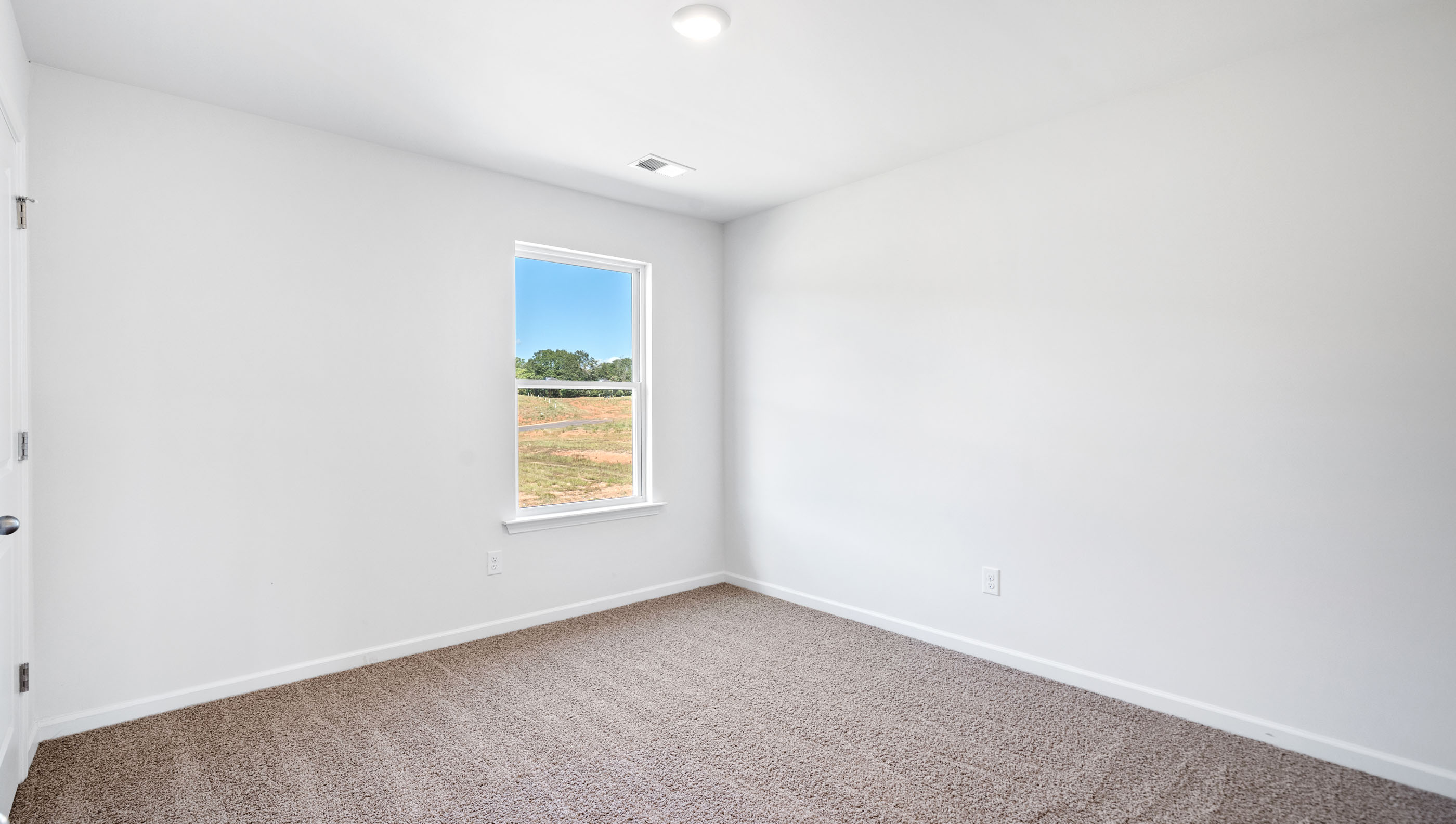 Bedroom with carpet and window.