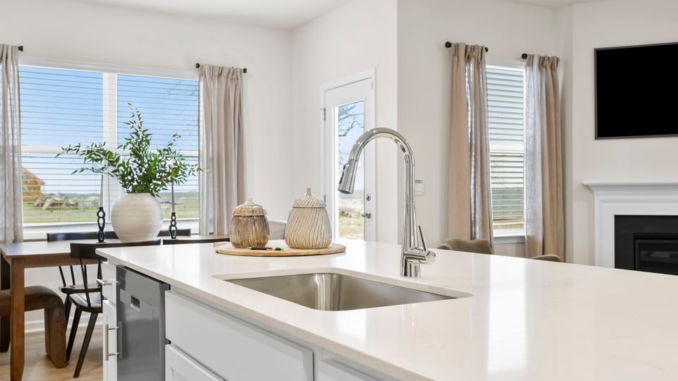 Kitchen with island with quartz countertops and stainless steel appliances.