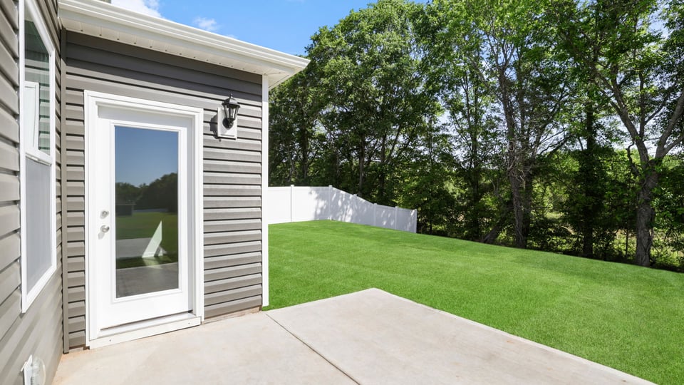 Back exterior of home with small patio.