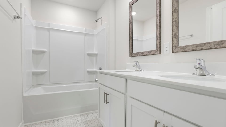 Bathroom with double vanity sink and tub.