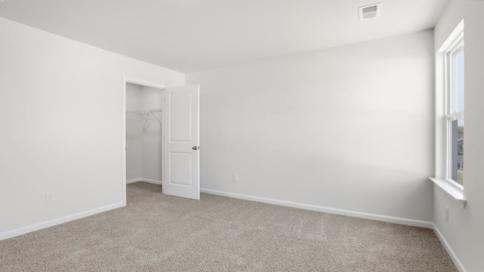 Bedroom with carpet and window.