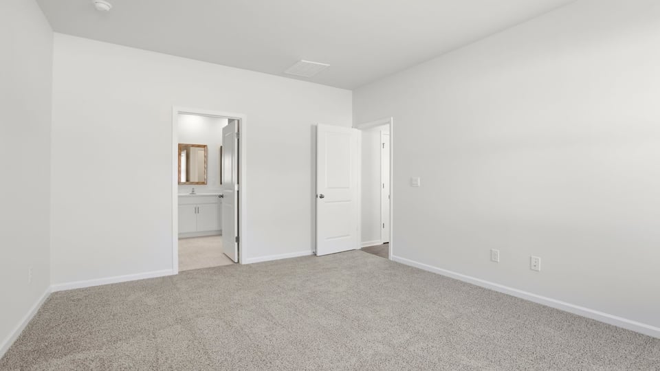 Bedroom with carpet and windows.