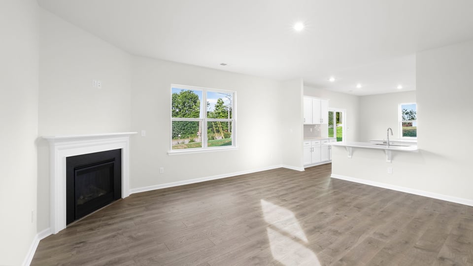 Living area with fireplace, window, and view of kitchen