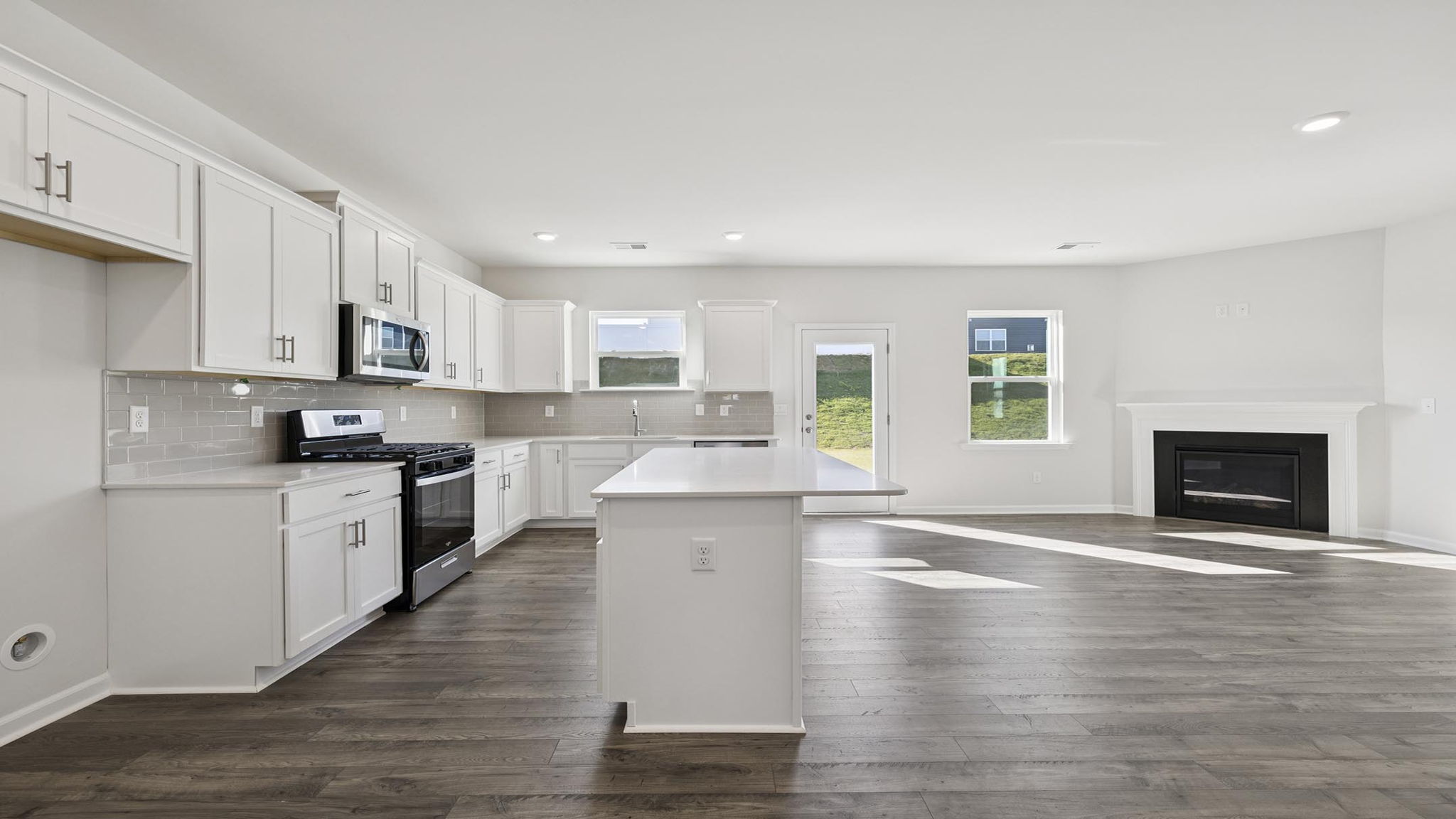 Kitchen and island with stainless steel appliances.