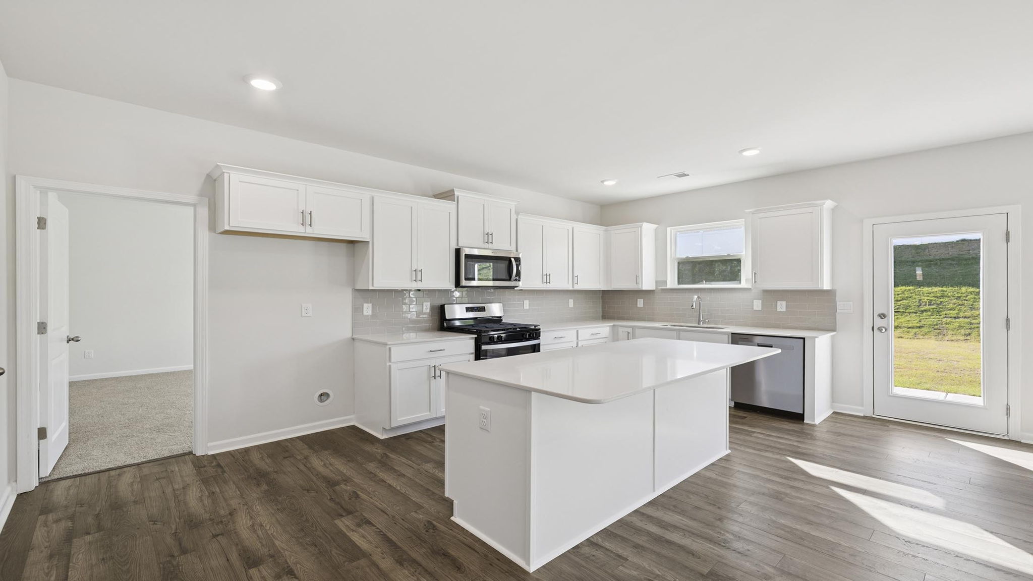 Kitchen and island with stainless steel appliances.