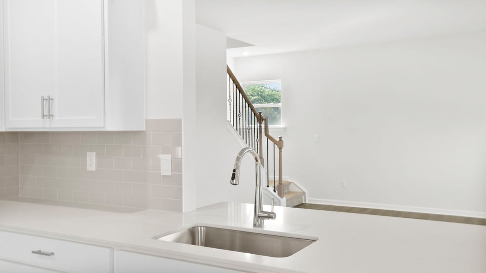 Close up of sink and island with view of stairs