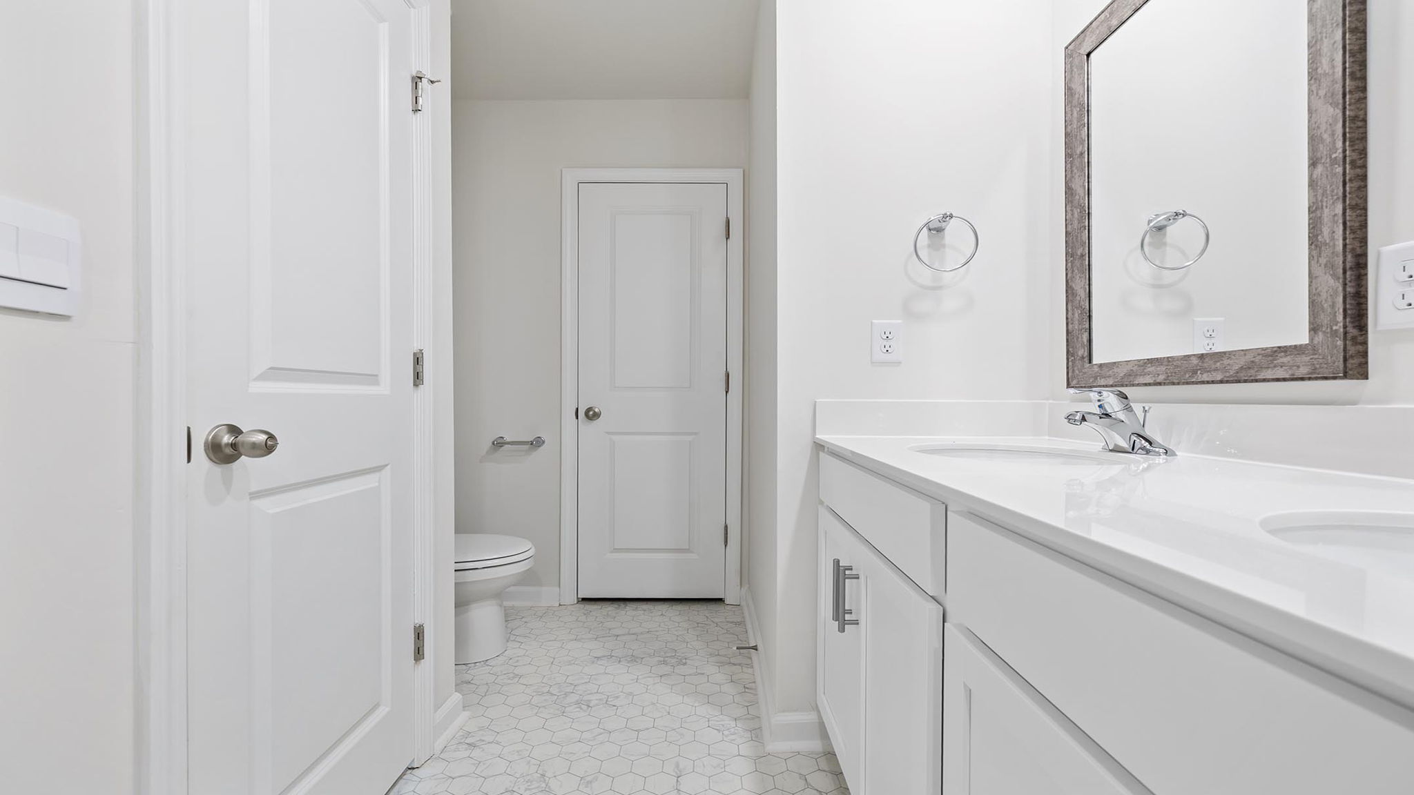Bathroom with double vanity sink and closet.