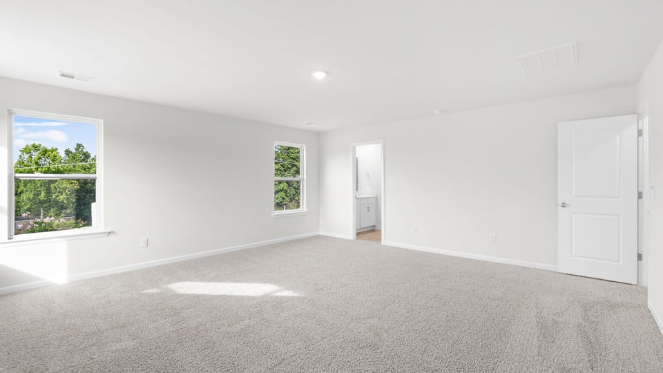 Primary bedroom with carpet and window