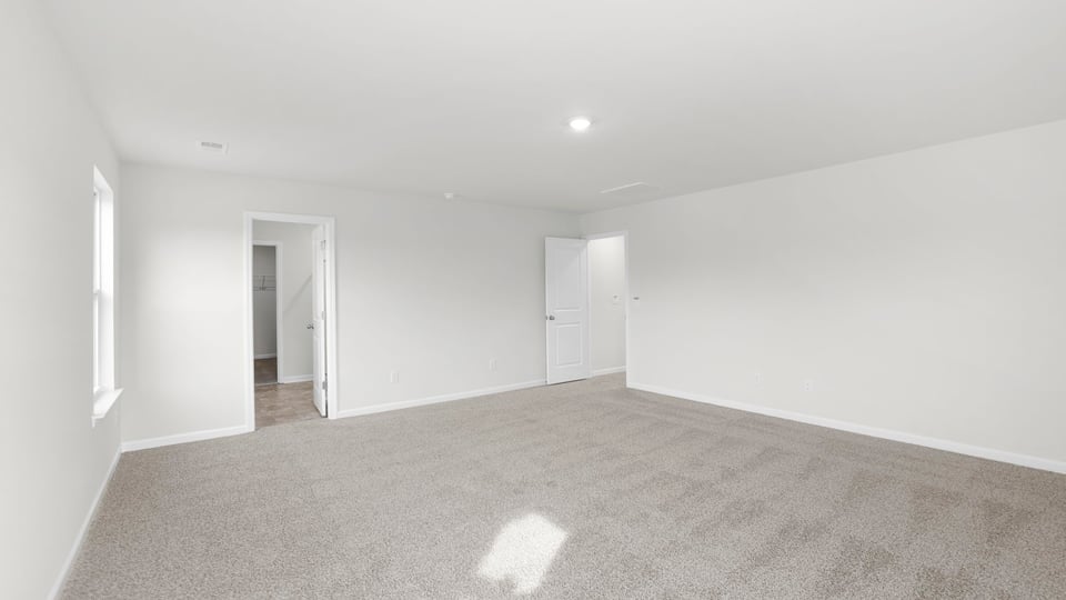 Primary bedroom with carpet and closet