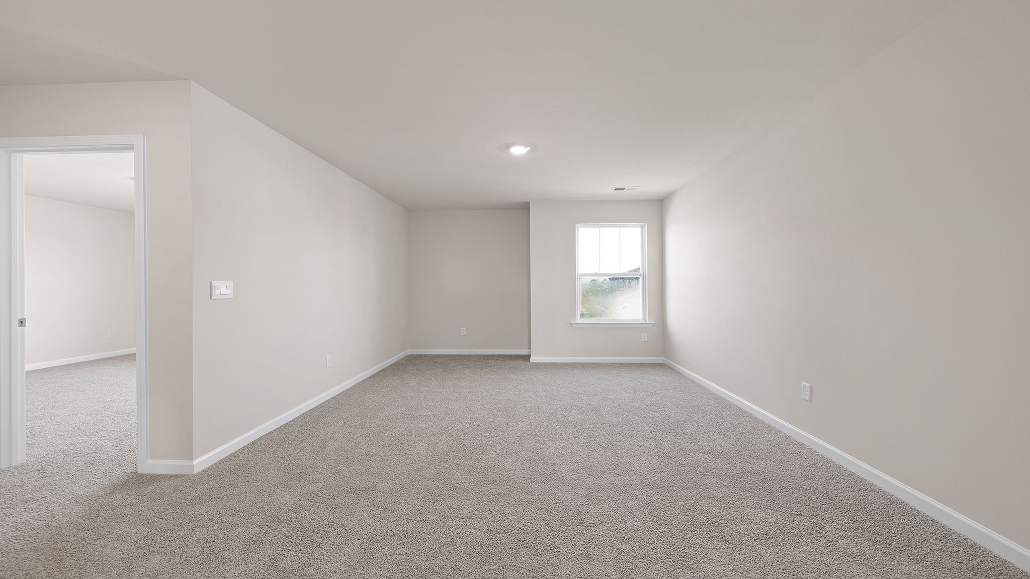 Loft area with carpet and window.