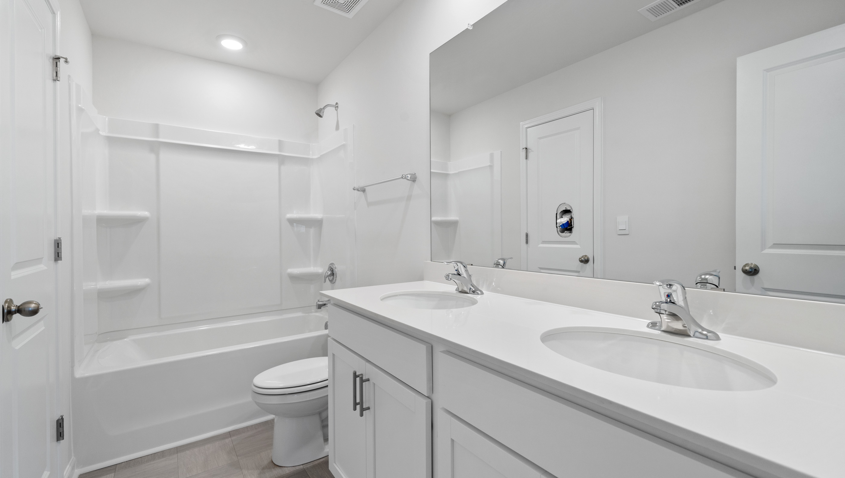 Bathroom with double sink vanity and tub.