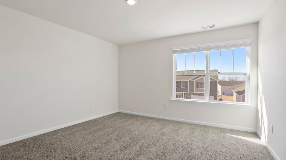 Bedroom with carpet and window.