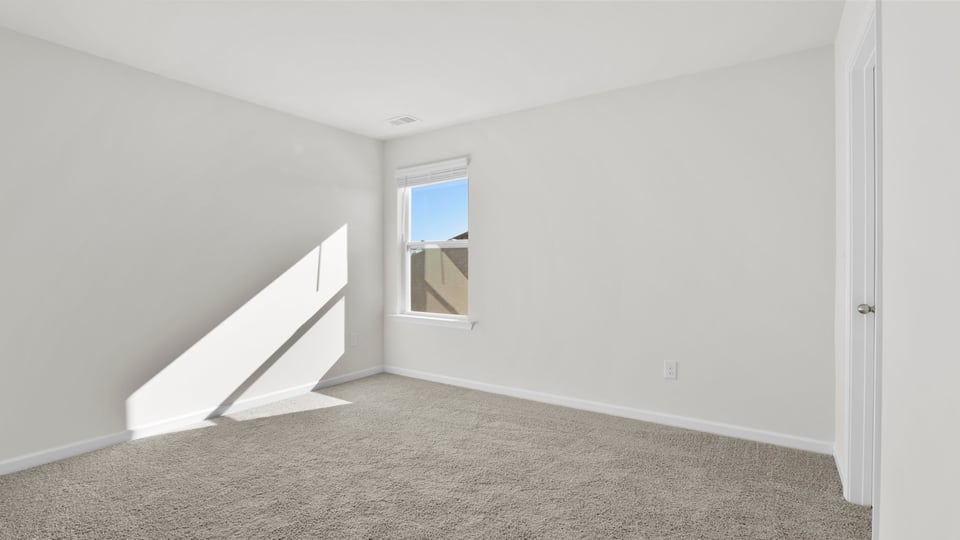 Bedroom with carpet and window.