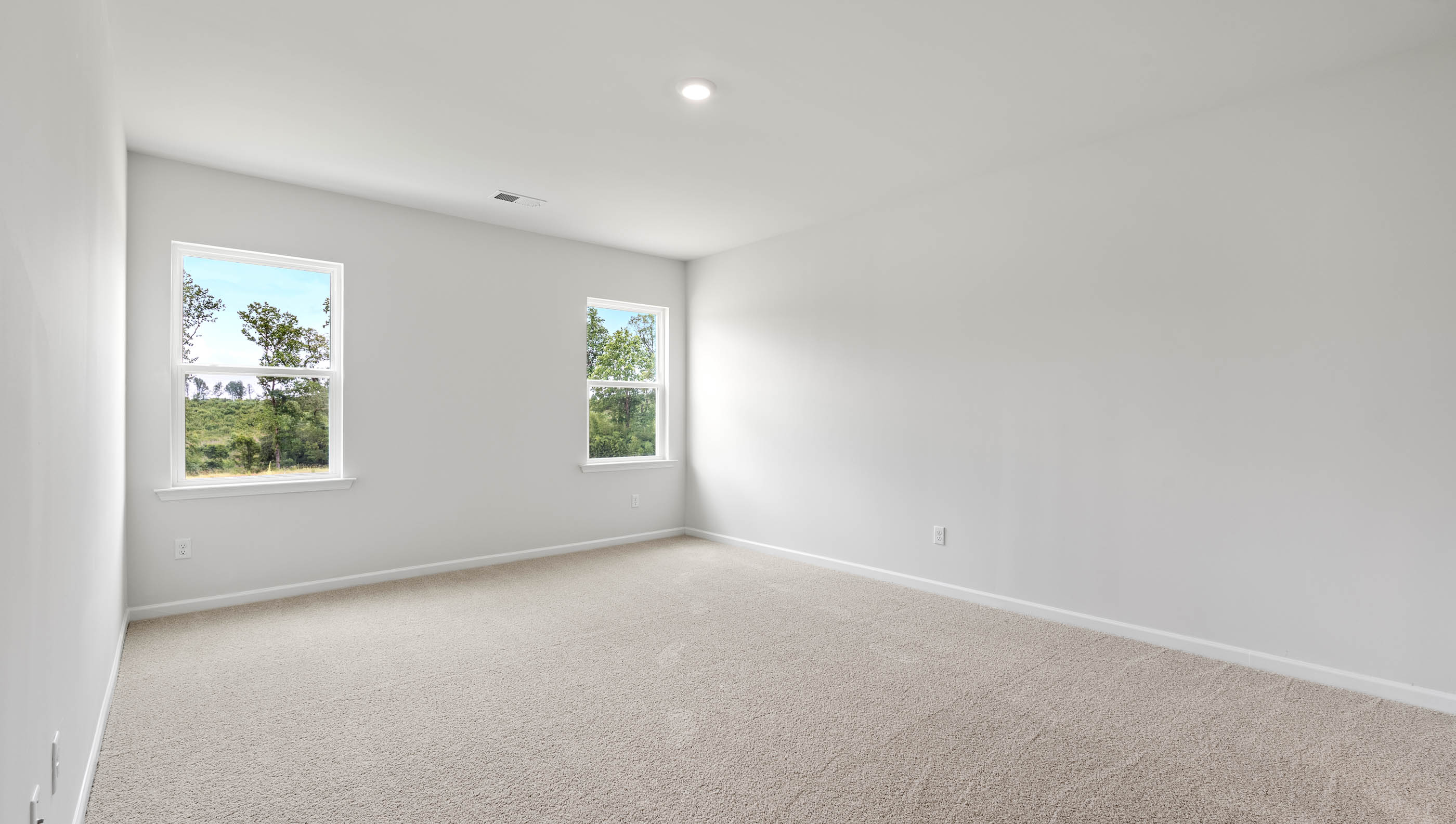 Bedroom with carpet and windows.