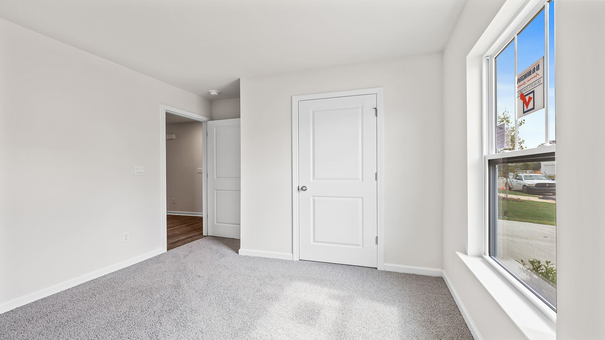 Front bedroom with large window and carpet.