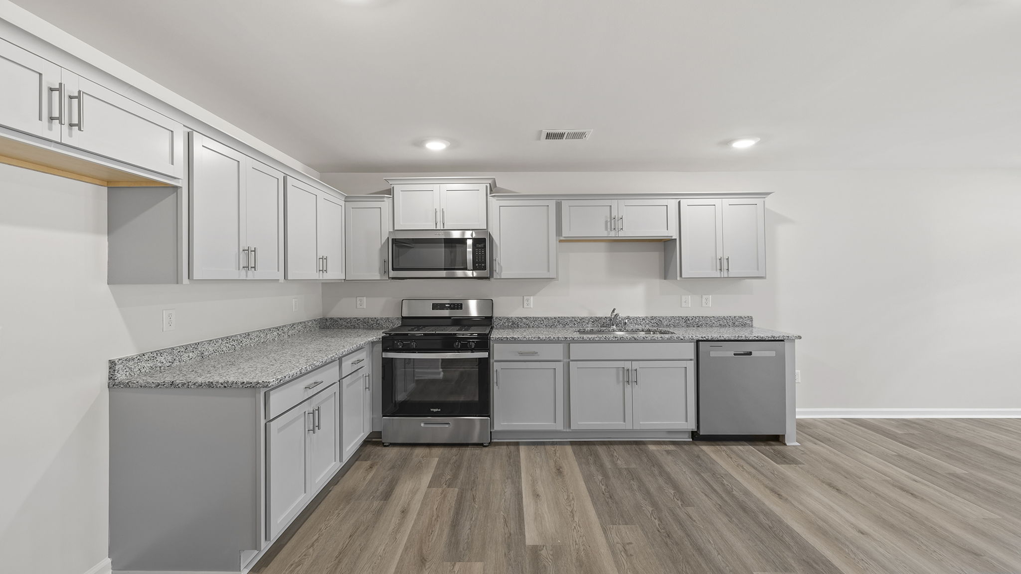 View of open kitchen with quartz countertops.