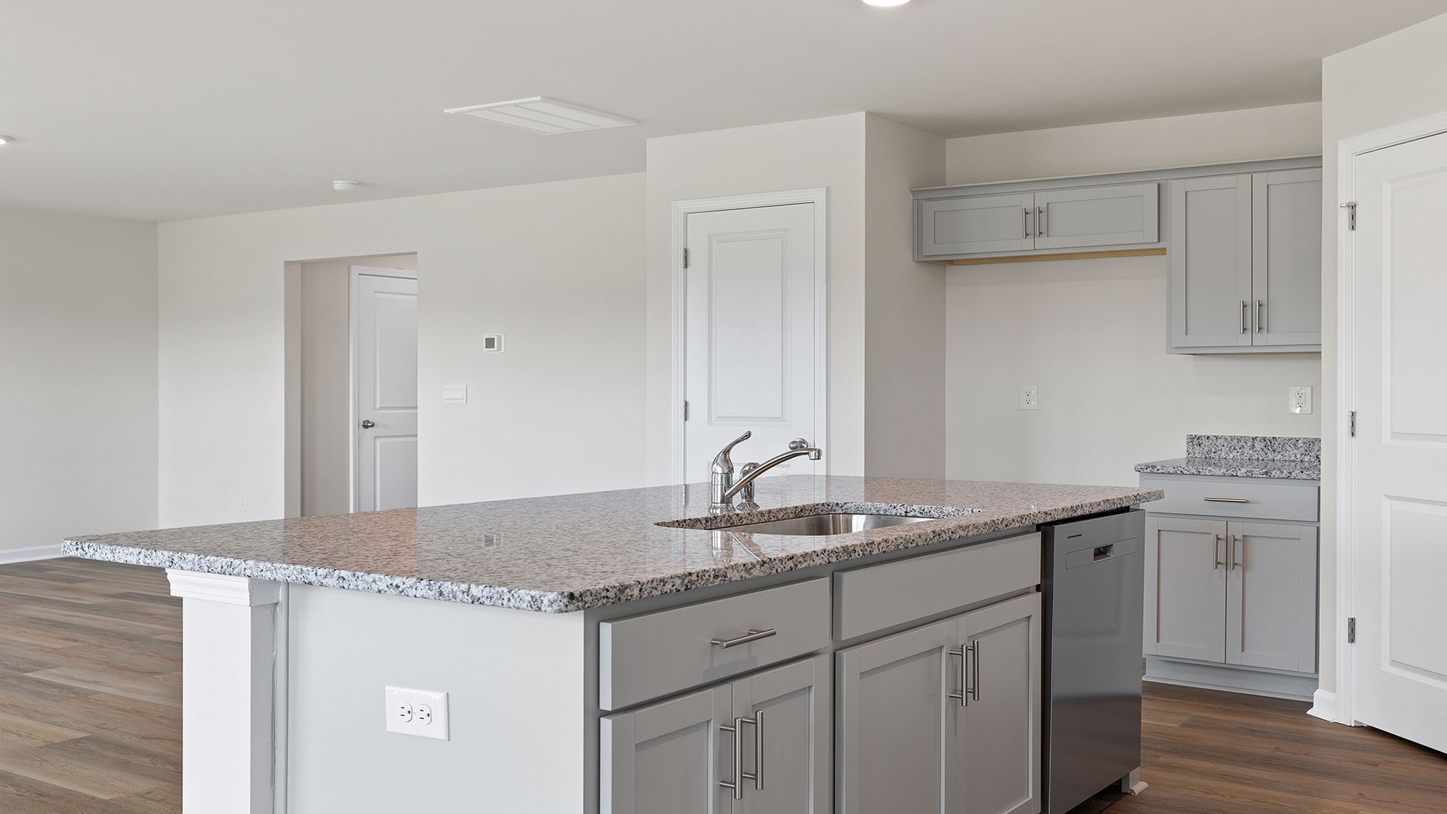 Kitchen island hosts the sink and dishwasher.
