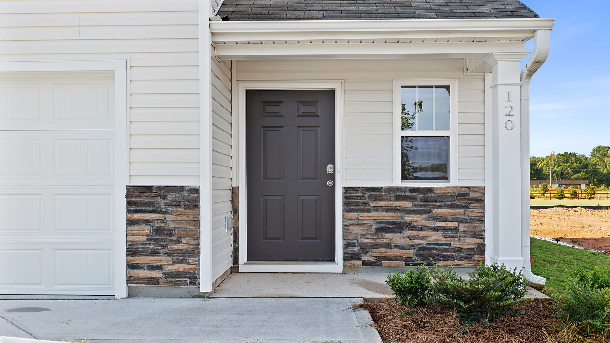 Inviting entry and covered porch accented by stone.
