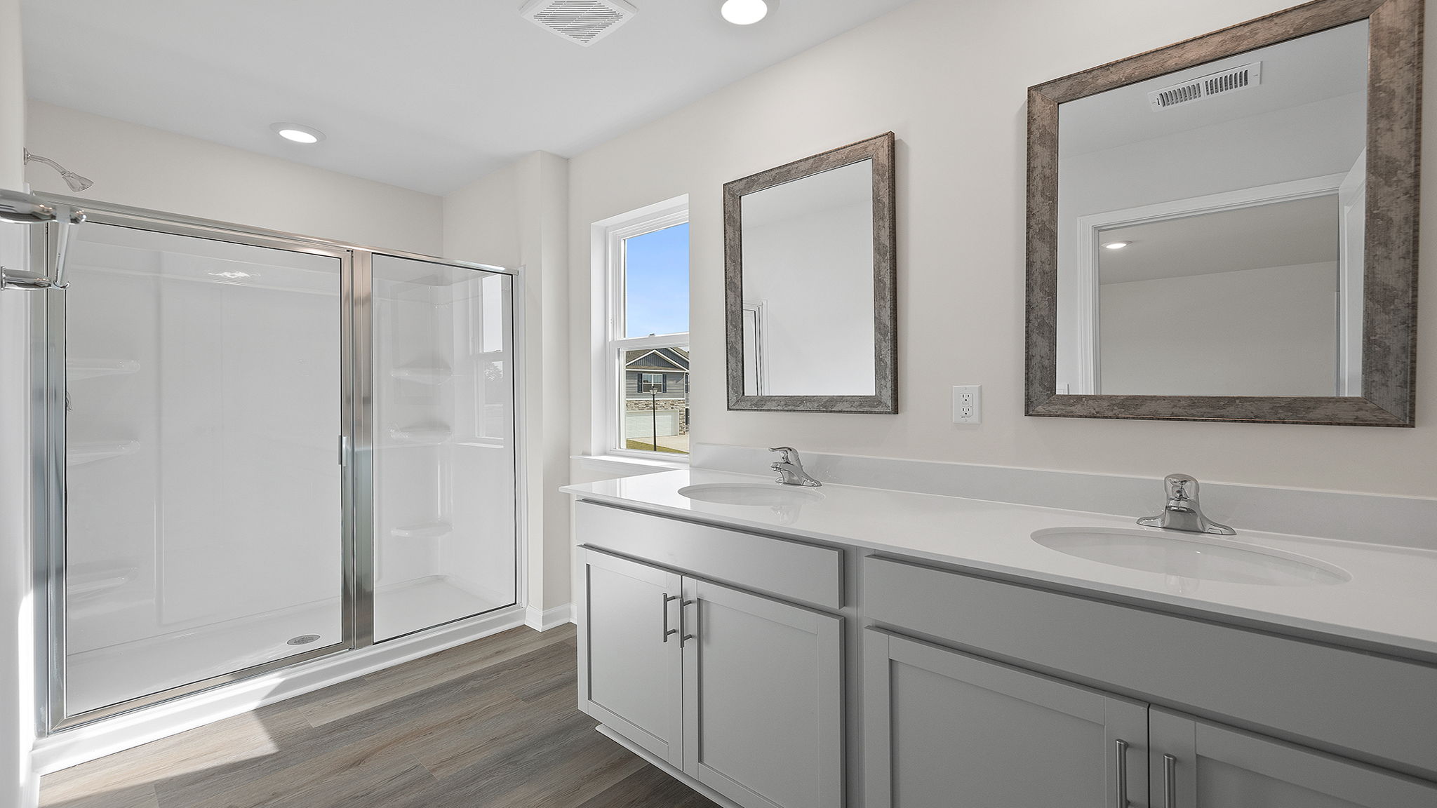 Primary bath with dual sink vanity and walk-in shower.