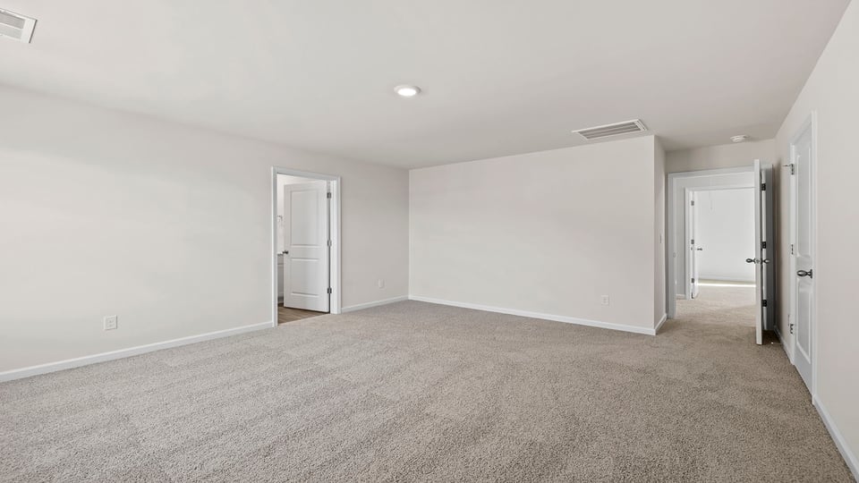 View of primary bedroom with large window and carpet.