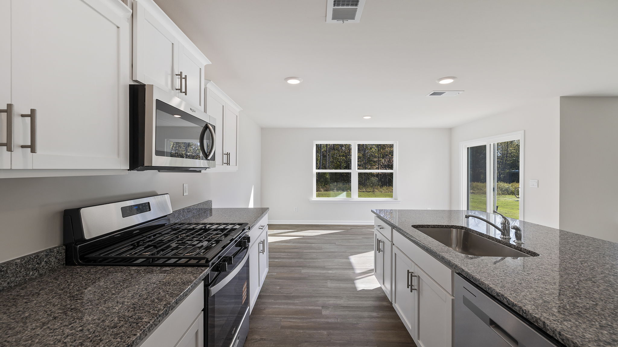 View from kitchen of dining area with large windows and door to the back yard.